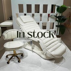 a white chair and ottoman sitting on top of a table