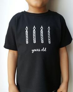 a young boy wearing a black shirt with arrows on it and the words years old written in white