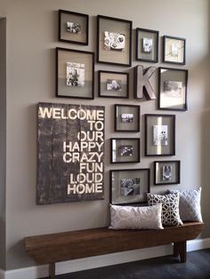 a bunch of framed pictures on the wall above a wooden bench with pillows and throw pillows