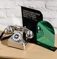 an old - fashioned phone sits on a table next to a plaque that reads, i know when that hotline is wrong