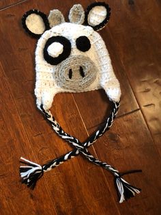 a crocheted cow hat on top of a wooden floor