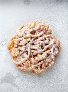 a powdered sugar covered pastry sitting on top of snow