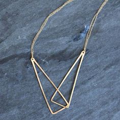 This gracefully geometric necklace features two long linked triangles strung on a double layer of delicate lacy chains. The center pendant feature elegantly accentuates the line along the collarbone. The combination or geometric edges and organic elements make this piece ideally suited to compliment any clothing style. Available in either 18 or 20 inch lengths Metal choices include sterling silver, 14k gold fill, or mixed metals. All Rebecca Haas Jewelry is handcrafted by me in my Southern Vermont Studio from recycled and ethically sourced materials. Modern Sterling Silver Double Chain Necklaces, Modern Sterling Silver Necklaces With Double Chain, Modern Sterling Silver Double Chain Necklace, Modern Double Strand Necklace With Adjustable Chain, Modern Sterling Silver Double Chain Jewelry, Modern Double Strand Necklace With Delicate Chain, Minimalist Triangle Metal Necklace, Modern Double Strand Everyday Necklaces, Modern Double Strand Necklace For Everyday