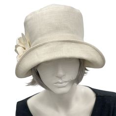 Handmade in the USAA hat isn't just about fashion, though the bespoke hats found here at Boston Millinery are the height of vintage style, it's about how you feel.It's about finding that finishing touch that make the corners of your lips uptick into a smile that shares your confidence and creativity.Wear this lovely Eleanor cloche hat to a garden party, the horse races, or an afternoon wedding and you’ll appear just as chic as Mary on Downton Abbey in today’s 20s. Meticulously crafted with care, Fitted Cream Panama Hat With Short Brim, Classic Brimmed Top Hat For Spring, Cream Fitted Sun Hat With Flat Brim, Fitted Cream Fedora For Spring, Chic Fitted Hats With Curved Brim, Chic Fitted Hat With Curved Brim, Fitted Brimmed Cream Hat, Fitted Cream Brimmed Hat, Short Brim Hat For Kentucky Derby