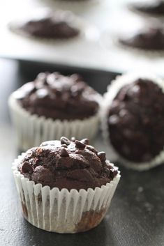 three chocolate muffins sitting on top of a counter