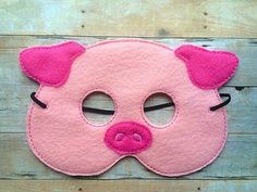 a pink pig mask with black ears and nose