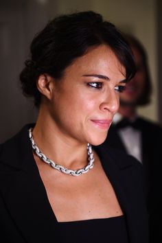 a woman wearing a black jacket and silver necklace