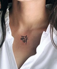 a woman with a tattoo on her chest that says om shant in black ink