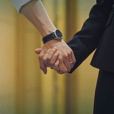 two people holding hands while standing next to each other