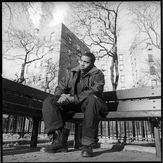 a man sitting on top of a wooden bench