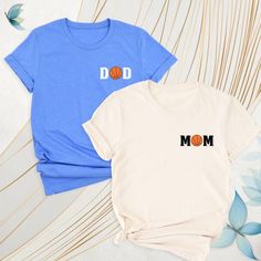 Basketball Mom Dad Matching Pocket Shirt, Basketball Family Tshirt, Basketball Mom Tee, Basketball Birthday Gift Dad Tee, Sports Dad Mom Tee. These are clothes designed for parents who are interested in basketball and whose children or relatives play this sport. These t-shirts are often emblazoned with "basketball"-themed graphics, text and colors, helping parents express their pride in supporting their child's game or practice. It is designed to serve both comfort and a supportive role and is o Casual Sports T-shirt For Father's Day, Cotton Tops For Father's Day Sports Events, Cotton Tops For Sports Events On Father's Day, Cotton Sports T-shirt For Father's Day, Sporty T-shirt With Graphic Print For Father's Day, Sporty Crew Neck T-shirt For Father's Day, Cotton T-shirt For Sports On Father's Day, Sporty Crew Neck T-shirt For Mother's Day, Father's Day Team Spirit Tops With Graphic Print