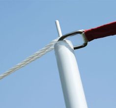 a close up of a white pole with a red rope on it and a blue sky in the background