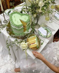 a table topped with lots of cake and plates covered in green frosted icing