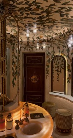 a bathroom with a sink, mirror and decorative wallpaper on the walls above it