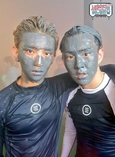 two men with their faces painted in blue and black, posing for a photo together