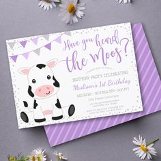 a purple and white birthday card with a cartoon cow on the front, surrounded by daisies