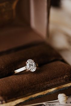 an engagement ring sitting on top of a book