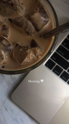 a glass bowl filled with food next to a laptop