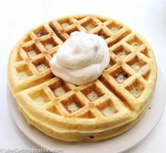 a waffle topped with whipped cream on a white plate