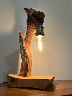 a light that is sitting on top of a wooden table next to a piece of wood