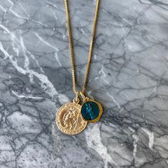 Pendant Details Pendant 1: Saint Christopher Size: 20mm by 20mm Material: 14k Gold Filled Pendant 2: Vintage Saint Anne Size: 15mm by 15mm Material: Two-Toned Blue Enamel Chain Details Material: 14K Gold Filled Thickness: 1mm Type: Box Chain Clasp: Lobster Blue Coin Pendant Jewelry As Gift, Blue Medallion Necklace For Anniversary, Blue Medallion Jewelry For Anniversary, Blue Gold Plated Jewelry With Charms, Blue Coin Pendant Jewelry, Blue Coin Pendant Jewelry For Gifts, Blue Medallion Necklace With Coin Pendant, Blue Gold-plated Jewelry With Charms, Blue 14k Gold Necklace With Charms