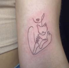 a small tattoo on the leg of a woman with a cat and bird in it