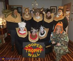 a group of people dressed up as cats and dogs posing for a photo in front of a sign that says zooper trophy wall