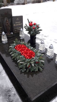 wreaths and flowers are placed on a table in the snow