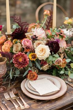 the table is set with flowers, candles and place settings for dinner guests to enjoy