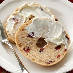 two pieces of bread on a plate with cream cheese and cranberry toppings