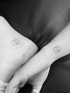 two people with matching tattoos on their hands