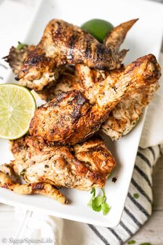 grilled chicken wings with lime and cilantro on a white platter, ready to be served