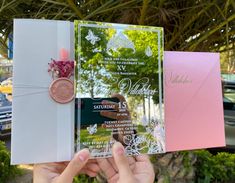 a person holding up an open wedding card