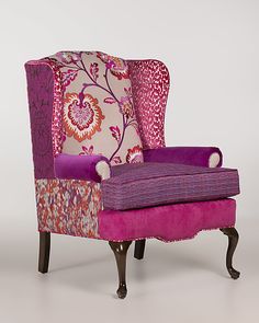 an upholstered pink and purple chair with floral print on the armrests