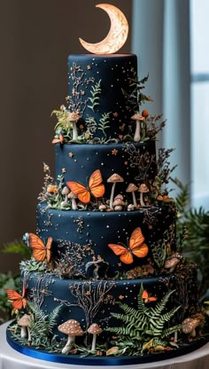 a three tiered cake with butterflies and mushrooms on the top is decorated in blue frosting