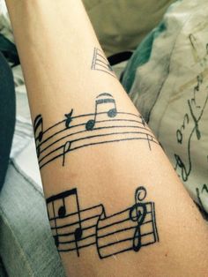 a person with a musical note tattoo on their arm