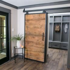 a large wooden door sitting inside of a living room next to a window with glass doors