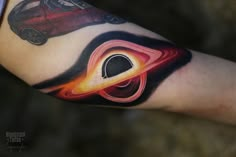 a person with a tattoo on their arm has an image of a car in the center