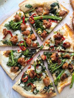 a pizza with spinach and pepperoni is cut into slices on a cutting board