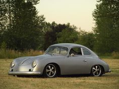 an old silver car parked in a field