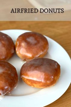 four glazed donuts on a white plate with the words airfried donuts