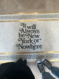 two people standing on the floor in front of a sign that says it will always be new york or nowhere