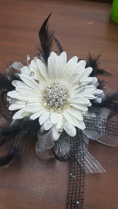 a white flower with black feathers on a table