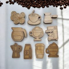 wooden cutouts of coffee related items displayed on white surface with coffee beans and shadows