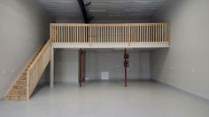 an empty garage with stairs leading up to the second floor