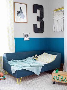 a child's bedroom with a blue bed and white rugs on the floor