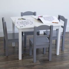 a table with chairs and a coloring book on it in front of a white wall