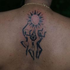 a man with a sun tattoo on his back is standing in front of the camera