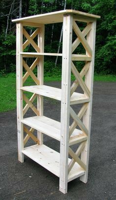 a wooden book shelf sitting on top of a dirt field