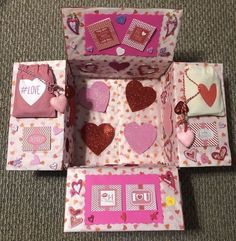 an open box with hearts on it and other items in the bottom half, inside